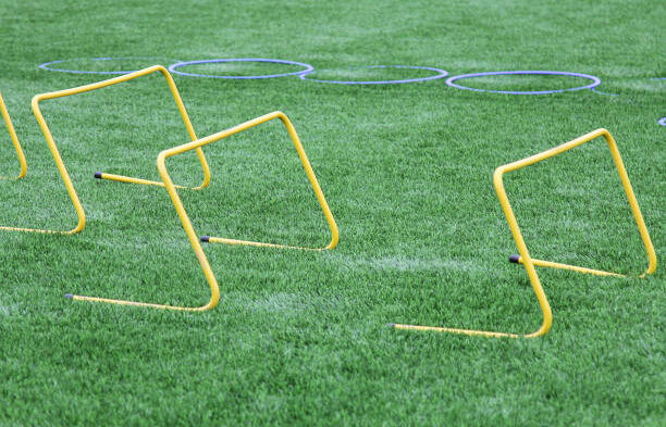 barras-salto Equipment for soccer training. Jumping barriers and training rings on an artificial lawn. Sports background.